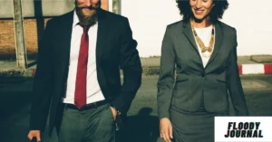 Best outfit ideas for work meetings professional man in navy suit red tie and woman in gray blazer walking together