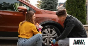 Couple doing easy car care at home cleaning red car wheel together in driveway"